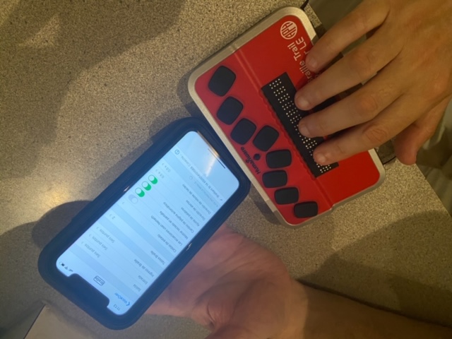 Foto de un iPhone conectado a una línea Braille.